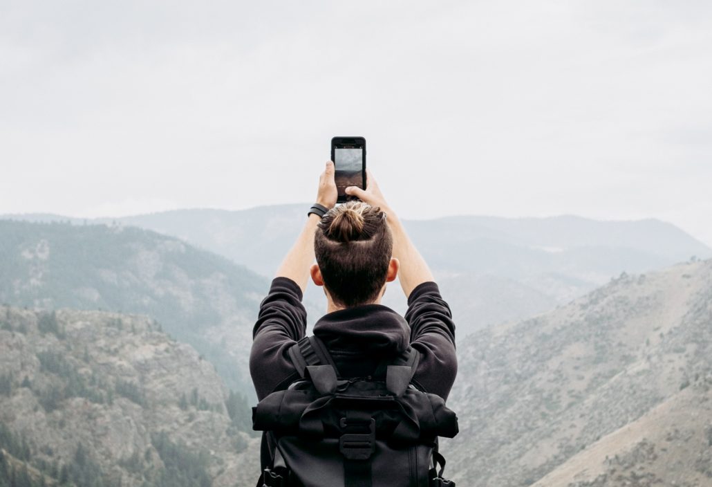 Mann nimmt Foto mit Smartphone auf